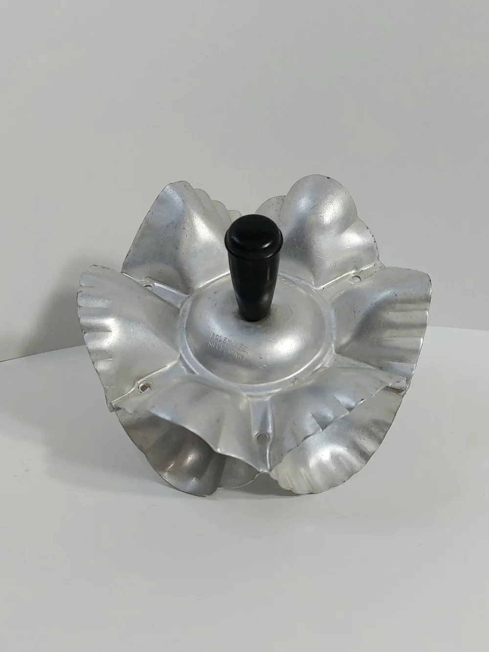 Foley 1950s Aluminum Foley rolling cookie and pastry cutter with black handles.